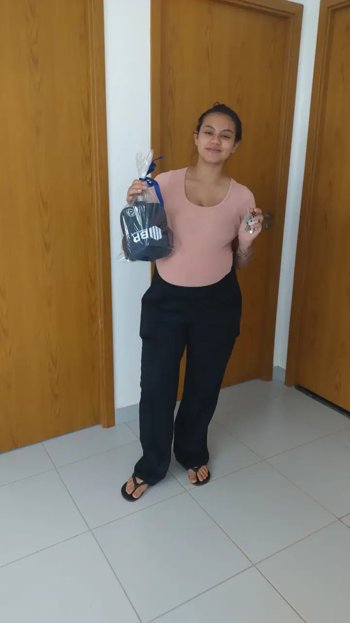 Moradora com as chaves e o kit de boas-vindas da bp