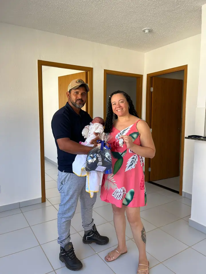 Casal com bebê recebendo as chaves do bp